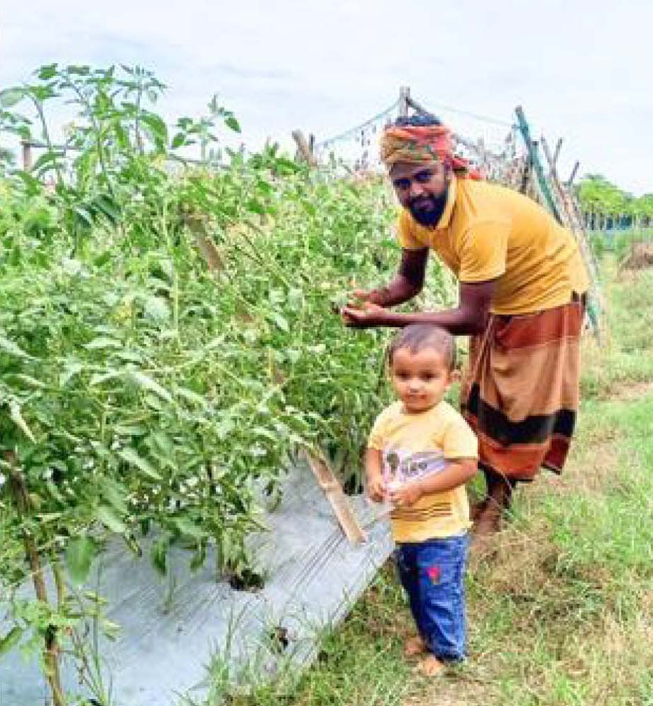 Sohel working in field alongside his child