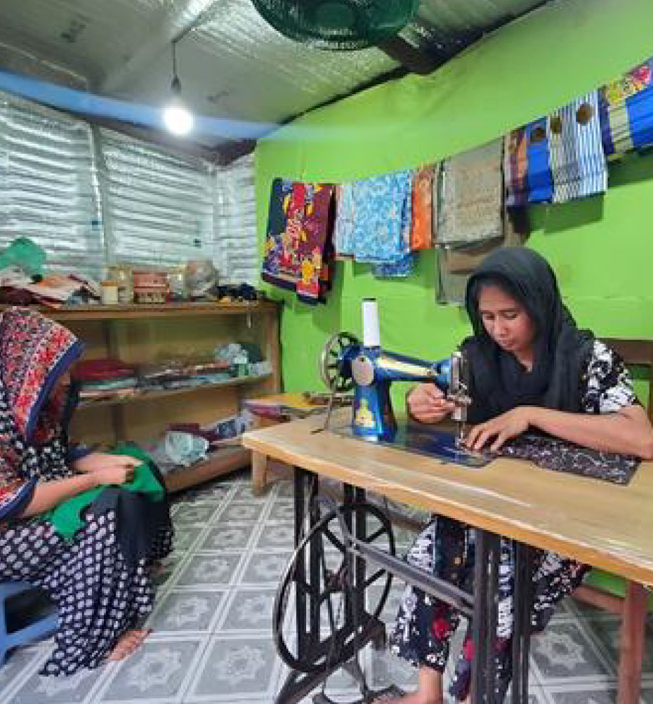 Shila showing her niece how to sew